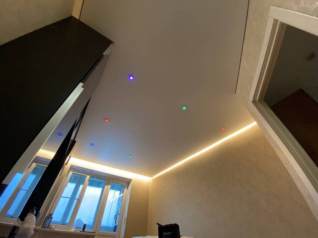 Белый парящий натяжной потолок с цветными светильниками